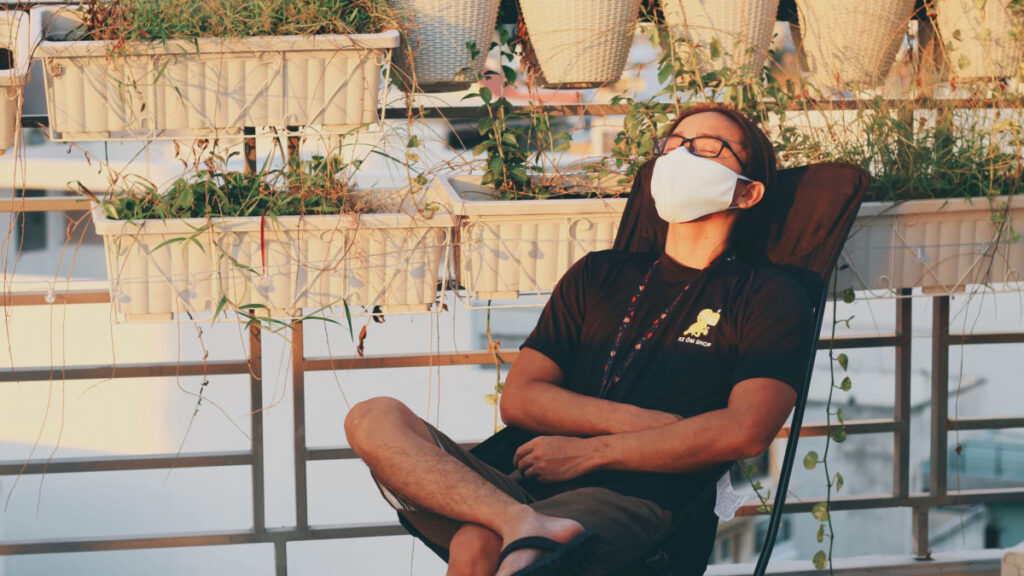 Person sitting peacefully outdoors in a garden