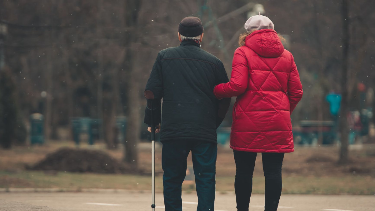 Support worker walking with a person in a park