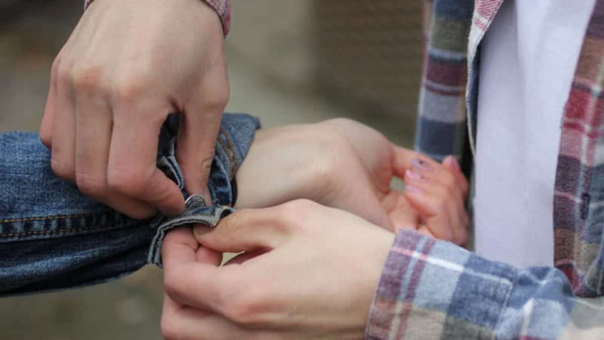 A support worker helping someone roll up their sleeve
